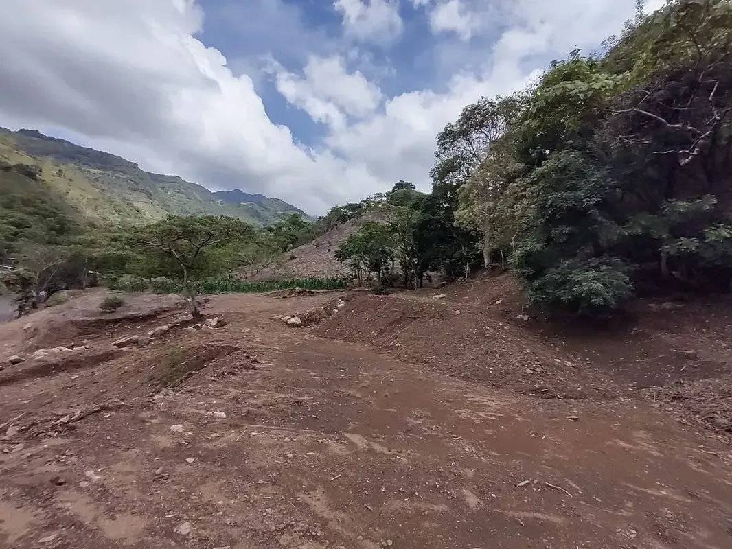 Terreno ganga  d más 1 hectare  con colinas, árboles y manantiales, amplio frente